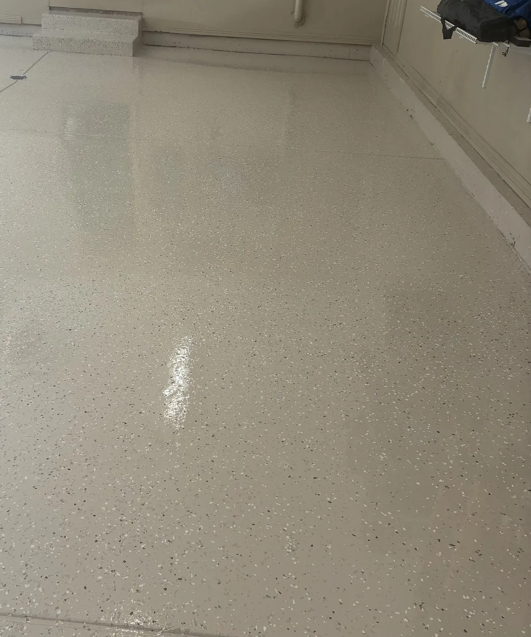 Glossy cream flake coating on a residential garage floor